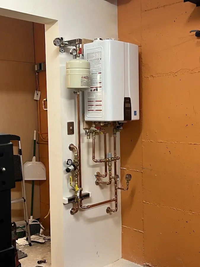 Plumbing technician inspecting water heater connections in Valdez